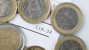 Idag behöver vi inte ha pengar rent fysiskt för att konsumera, vilket har lett till att folk inte reflekterar lika mycket över sitt konsumtionsbeteende. En hög med mynt ovanpå en räkning på 118 euro.