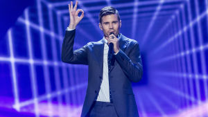 Robin Bengtsson Man i kostym sjunger i mikrofon