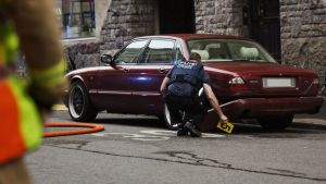 Polisen undersökte gärningsmannens röda Jaguar efter vansinneskörningen fredagen den 28 juli 2017. En polis utför en teknisk undersökning av en bil på platsen där en kvinna omkom och flera skadades då en person vansinneskörde i Helsingfors på fredagskvällen den 28 juli 2017.
