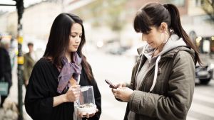 Varannan svensk använder sig av mobilapplikationen Swish. Kvinna betalar med mobilappen Shwish i stället för med kontanter.