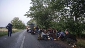 Asylsökande personer sitter vid den ungersk-serbiska gränsen den 27 juni 2015. Asylsökande personer sitter vid den ungersk-serbiska gränsen den 27 juni 2015.