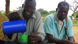 Efter kyrkobesöket på söndagar samlas man för att umgås. Francis pappa häller upp en fermenterad dryck gjord på majs. män i norra uganda