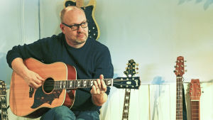Låtskrivaren och producenten Niklas Nylund har varit med sedan 80-talet och sett hur branschen har förändrats. Niklas Nylund spelar gitarr i sin studio i Borgå.