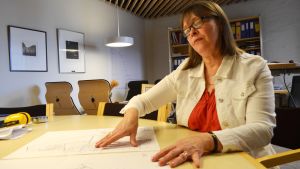 Margareta Kull-Poutanen beundrar ritningarna på det nya biblioteket. Biblioteksdirektör Margareta Kull-Poutanen granskar ritningarna för det nya biblioteket.