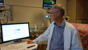 Sture Andersson granskar en monitor som visar ett närliggande spädbarns hälsouppgifter. I ett lyckat försök har man skickat sådant här datamaterial till en superdator för analys. Sture Andersson, HNS