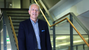 Pekka Puska är läkare och har varit generaldirektören för Institutet för hälsa och välfärd. Pekka puska seisoo portaikossa