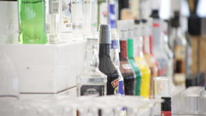 Polisen ser att direkt samband mellan alkohol och våldsbrott. Alkoholflaskor bakom disken på en bar.