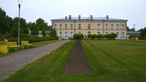 Så här ser rosenrabatterna ut i år. I bakgrunden borgå gymnasiums gula hus, i förgrunden en lång blombänk som är nöstan bara mylla.