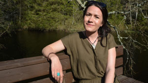 Annika Åman började sin skådespelarbana på Oravais teater. kvinna sitter på bänk vid vattendrag