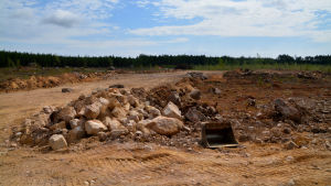 Mängden starter och landningar är 2000-4000 per år. Den blivande landningsbanan tar form i sand, en stenhög syns på bilden samt en skopa.