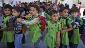 Skolbarn som väntar på att få komma in i en lågstadieskolbyggnad i Aleppo-distriktet i Syrien den 23 september 2013. Under den här tiden pågick en stor UNICEF-kampanj för att få barn att sätta sig på skolbänken igen trots oroligheterna landets inbördeskrig fört med sig. Skolbarn i Aleppo i Syrien
