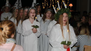Frida Huhtamäki johdattaa laulavaa Lucia-kulkuetta. Bobäckin koulun Lucia-kulkue
