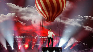 Av rösten att döma får Irlands Brendan Murray i sig en del helium från ballongen Man stående i kuliss formas som en luftaballong