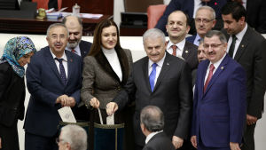 Premiärminister Binali Yildirim ( i mitten) röstade i praktiken för att göra sig själv arbetslös eftersom lagen innebär att presidenten utser och leder regeringen Premiärminister Binali Yildirim ( i mitten) röstade i praktiken för att göra sig själv arbetslös eftersom lagen innebär att presidenten utser och leder regeringen