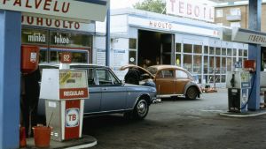 Teboil oli ennen Tb. Nimi viitasi trustivapaaseen bensiiniin. Kuva on vuodelta 1970. Huoltamot, huoltoasemat. Teboil-huoltoasema. Teboil, huoltamo. Bensapumppu. Henkilöautoja, mm Volkswagen (Kupla-volkkari) konepelti ylhäällä.