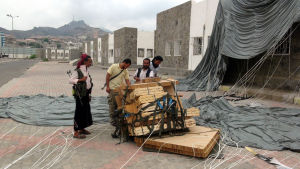 Krigare i Aden ser över vapen som fälldes med fallskärm av det saudiarabiska flygvapnet. Krigare som bekämpar Houthi-rebellerna går igenom en saudiarabiska vapen som fälldes i staden i april 2015