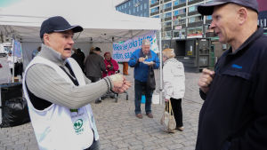 Mika Kavander diskuterar mjölkpriser med förbipasserande. Mika Kavander deltog i jordbrukares protest på Salutorget i Åbo.