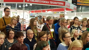 Lyssnar på Märta Tikkanen. Bokmässan 2015, publik kring märta tikkanen och intervjuaren nina nyman.
