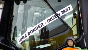 Flera olika banderoller med starka budskap syntes bland traktorerna. Traktor med banderoll där det står "Inga bönder - ingen mat".