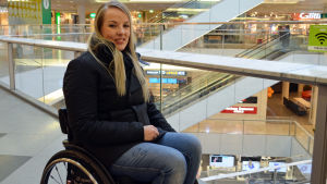 I ett köpcentrum är det lätt att röra sig också med rullstol. Anni Täckman sitter i en rullstol i ett köpcentrum