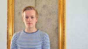 Jonathan rehn framför en inramad ruta av omålad originalvägg. TF:s ordförande Jonathan Rehn