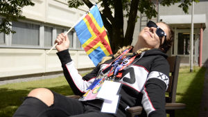 Sommar och sol, då är allting bra! Pernilla Karlsson solar med Ålands flagga i handen