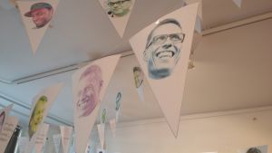 Festligt värre i galleriets tak. Men bakom vimplarna finns mörkare budskap. Vimplar med Alexander Stubbs ansikte.