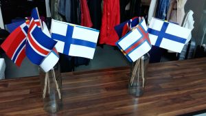 Vi får inte glömma vår nordiska språktillhörighet, säger kongressdeltagarna. Nordiska flaggor i vaser.