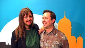Mia Haglund och Larrie Griffis. Mia Haglund och Larrie Griffis poserar framför en Yle Vega backdrop.