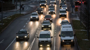 De flesta arbetsresorna görs med bil, både i tätorter och på landsbygden. Aamuruuhka, Etelä-Haaga, Vihdintie, autojen valot, ruuhka, syksy, talvi, sade