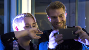 Jarkko Niemi poseeraa fanin kanssa kännykkäkameralle Syke-fanitilaisuudessa.