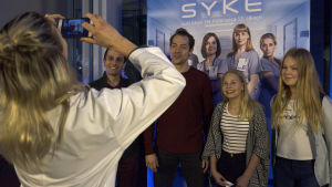 Syke-sarjan näyttelijät poseeravat kännykkäkameralle faniensa kanssa.