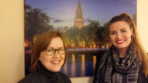 Sari Ruusumo och Lotta Bäck från Visit Turku är glada över turismutvecklingen i Åbo. Sari Ruusumo och Lotta Bäck från Visit Turku framför en plansch över Åbo Domkyrka och Biblioteksbron.