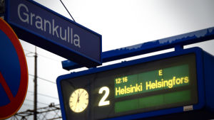 Det fanns en tid då också jag tyckte att det bästa med Grankulla var närheten till huvudstaden. Järnvägsskylt: Grankulla, samt tågtidtabellsskylt som annonserar tåg mot Helsingfors.