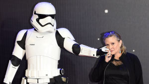Carrie Fisher poserar med en Stormtrooper i december 2015. Carrie Fisher håller en Starwars-krigare, även kallad Stormtrooper, i handen och trycker den mot sin kind i december 2015.