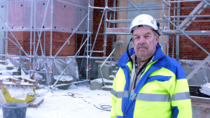Ingmar Norrback är projektchef för renoveringen. Ingmar Norrback står framför Kristinestads kyrka som renoveras.