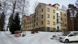 Höghuset i närheten av slukhålet riskerar inte att rasa. Gammalt gult höghus i sten i byn Aijala i Kisko.