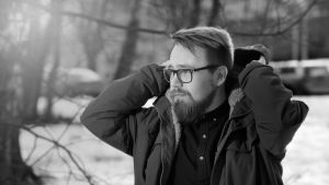 Mies, Samu Reijonen laittaa ulkona huppua päälleen.