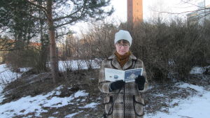 Kirjabloggaaja Liisa Pihlaja lukee talvisessa säässä Mauri Kunnaksen Koiramäen joulukirkkoa.