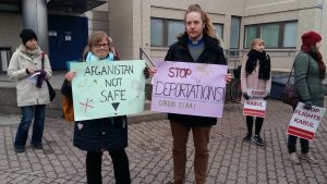 Demonstranter håller upp skyltar om att Afghanistan inte är tryggt. Demonstranter utanför polishuset i Böle, som protesterar mot att asylsökande utvisas från Finland.