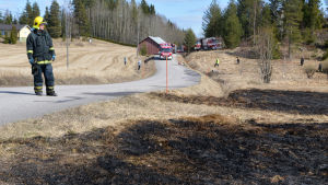 Sex enheter från räddningsverken i trakten var på plats. brandman står på pohjakkavägen och ser på bränd åker, i bakgrunden räddningsfordon