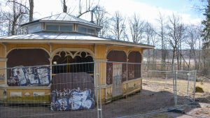 Paviljongen hade sjunkit in i marken, nu står den på träbjälkar och marken omkring ska bearbetas. paviljongen sett bakifrån, byggnaden har lyfts upp på träbjälkar