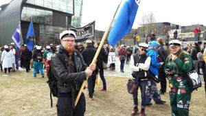 Tomas Sjöblom är nyutexaminerad magister från Helsingfors universitet. Han säger att nedskärningarna känns av på stämningen i universitetet. "Alla är oroade". Tomas Sjöblom deltar i vetenskapsmarschen i Helsingfors.