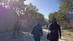 Efter flera självmordsbombdåd är höga betongskyddsmurar en allt mer vanlig syn i Kabul. Två kvinnor och en cyklist på en sandväg i Kabul invid en hög mur.