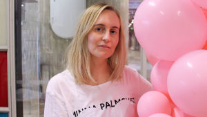 Minna Palmqvist bär en t-shirt från sin egen kollektion. Minna Palmqvist poserar med rosa ballonger