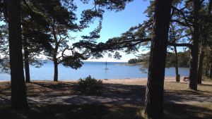 Många vill besöka stränderna i Hangö. Sandstrand i Hangö med blått vatten och blå himmel. Stranden heter Plagen.