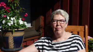 Marianne Nyqvist-Mannsén. Marianne Nyqvist-Mannsén sitter vid ett bord med en blomkruka på.