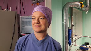 Camilla Stenfelt på Fertilitetscentrum säger att deras gräns för att använda de nedfrysta äggcellerna är 45 år. Camilla i rosa skyddsmössa och blå skyddsdräkt, på laboratoriet, småler, tittar snett åt sidan, slangar i bakgrunden