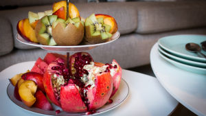 Hedelmälautanen, jossa kiwi, granaattiomena ja persikka