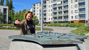 Professor Laura Kolbe granskar en miniatyr av stadsdelen.. Laura Kolbe står vid en miniatyr av stadsdelen Rönnbacka.